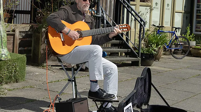 Well-known Clonakiilty musician Les Clague strumming in the sunshine in Spiller's Lane, Clonakilty.   (Photo: Martin Walsh)