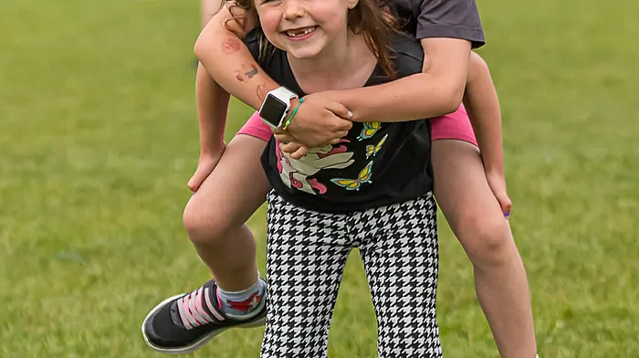 Niamh O’Neill giving Ciana Regan a piggy back at the Castletownbere GAA pitch festival. (Photo: Anne Marie Cronin)