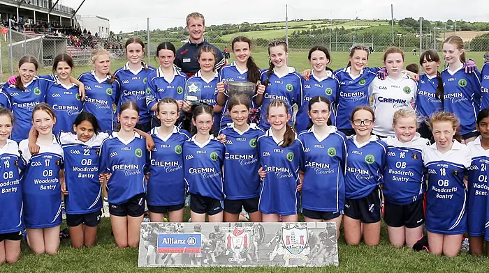 Scoil Mhuire agus Bharra, winners of Roinn 1 Girls, with Cork footballer Ruairí Deane.(Photo: Paddy Feen)