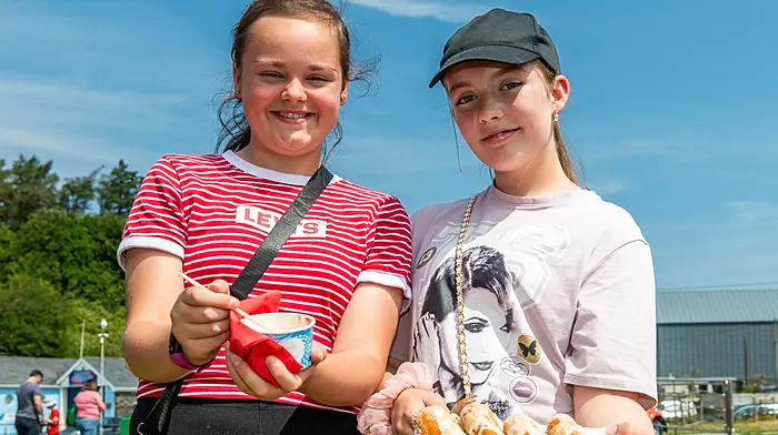 Bantry, West Cork, Ireland. 10th Jul, 2026. Bantry basked in 26°C temperatures today as Met Éireann has classed the hot weather as a heatwave. Enjoying some fun fair food were Farrah Collins, Kealkill and Emily McCarthy, Ballylickey. Picture: Andy Gibson