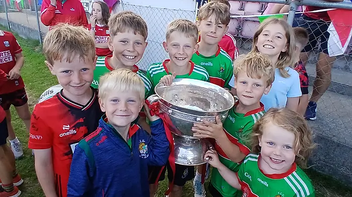 Clonakilty cousins with the Tom Markham Cup at the Clonakilty GAA homecoming celebration for Cork’s All-Ireland minor football champions last Friday.  From left: Oisín Lyons, Sonny Lyons, Seán Lyons, Fionn Lyons, Scott Riordan, Lauren Riordan, Tomás Lyons and Tessie Lyons.