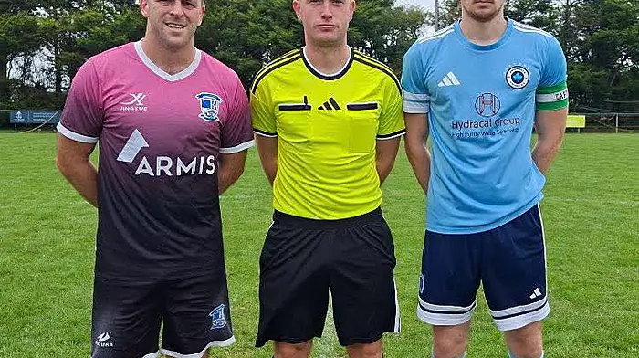 Ballinhassig AFC captain Fionn Lawlor, referee Ricky Parker and Avondale United captain Matthew McKevitt.