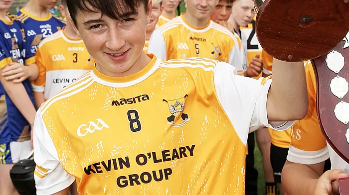 Hamilton High School captain Danny Connolly raises the Raymond Lyons Perpetual Memorial Cup. (Photo: Paddy Feen)