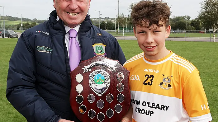 Carbery GAA Board Communications Officer Tim Buckley presents the Raymond Lyons Memorial Shield to Hamilton High captain Noah Collins. (Photo: Paddy Feen)