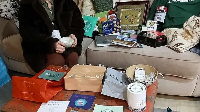 Winter Solstice market raffle winner Kate Kelly from Goleen sitting among her mountain of goodies.  Kate thanked all the Schull traders for their generosity as her prize had the most amazing selection of gifts.