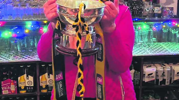 The All-Ireland junior champion cup, and a good few of the Kilbrittain hurling team, arrived to O’Donovan’s Bar, Ballinadee over the weekend where proprietor Mary O’Donovan posed with the trophy.