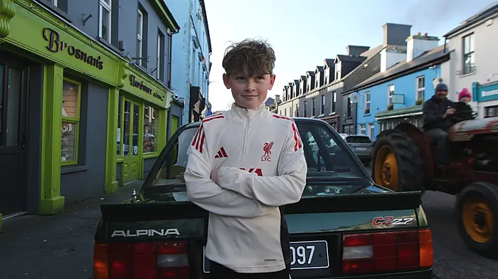 Callum Hegarty posing beside a vintage car parked on Main Street, Schull during the St Brigid's Day celebrations.  (Photo: Carlos Benlayo)