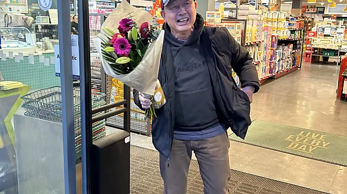 Schull photographer Carlos Benlayo leaving Brosnan’s Centra supermarket with a bouquet of flowers and chocolates in hand as Valentines gifts for his wife. Photo courtesy of Jeremy Brosnan.