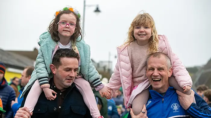 REPRO FREEFriends Mia Barry and Charlie Collins hold hands as they march with their fathers Dave Barry and Ian Collins from Kinsale GAA at the annual Kinsale St Patrick Day parade.Picture. John Allen