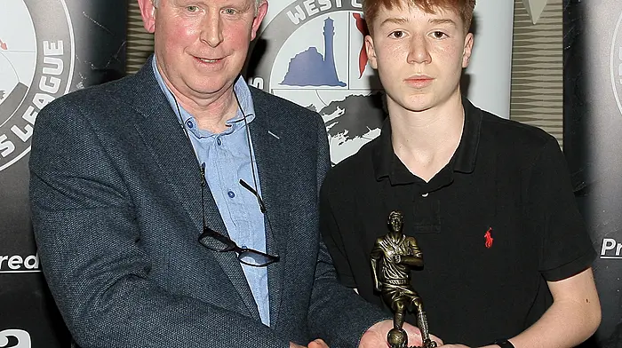 2025 Boys U14 Player of the Year Fiachra Garrett, Skibbereen AFC, receives his award from Declan Deasy. (Photo: Paddy Feen)