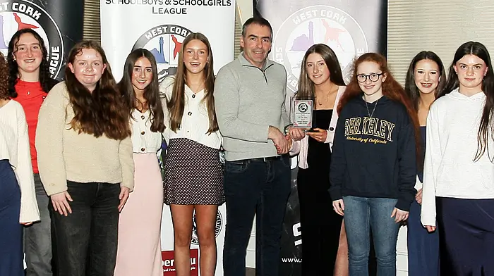 Tadhg Curtin, West Cork Schoolboys and Schoolgirls League Treasurer, presents the 2025 Team of the Year award to joint winners, Drinagh Rangers U16 girls. (Photo: Paddy Feen)
