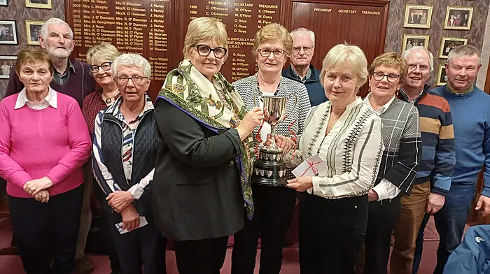 Carmel Murphy and Jane Ross (front centre) receiving the Eileen O'Brien cup from Maria Farrell (president, Curraghcrowley Bridge Club).  Back: Margaret Shorten, James Ferguson, Vera Chambers, Noreen Hurley, Eddie Moloney, Margaret O'Flynn, Jerry O'Flynn and Pat O'Donoghue. Jerry O'Mahony is missing from the photo.