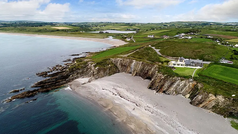 The Henrys’ former home was designed to take maximum advantage of beach views, above, and has a stunning deck, top, with Galley Head to its left.