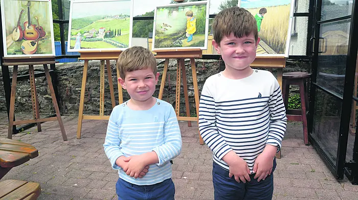At the annual Gardens and Galleries festival at Innishannon were Iarla and Liam Walsh in front of paintings by their grandad, artist Gerry Larkin. (Photo: Denis Boyle)