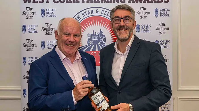 Former Southern Star editor Con Downing receives an award from Southern Star managing director Seán Mahon.