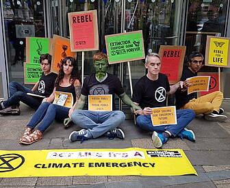 Protesters Glue Themselves To...